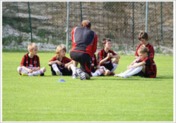 Entrenador y niños en el AC Milan Junior Camp