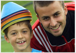 Niño y entrenador de fútbol en el campamento de verano de AC Milan
